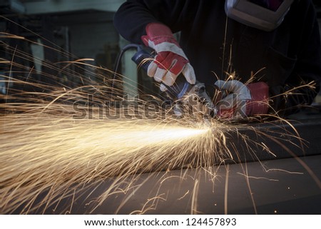 Grinding closeup with protection gloves and sparks