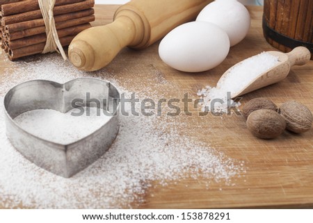 Baking ingredients and tools on brown wood cutting board