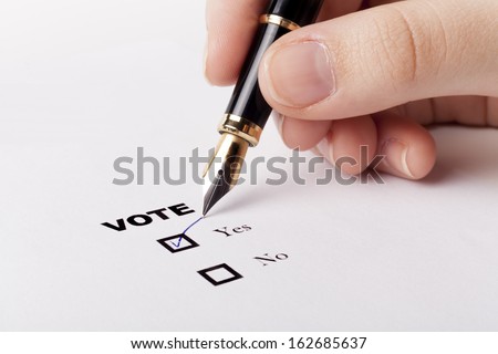 Woman hand voting yes in check-box with blue fountain pen