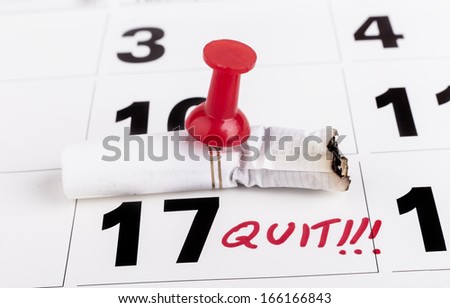 Quit smoking deadline with cigarette butts nailed with red pin to calendar