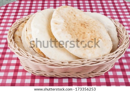 israeli flat bread in basket on red table