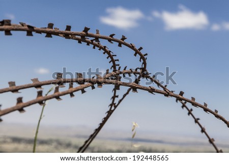 Old rusted Barbed wire closeup country borders with blue sky and white clouds