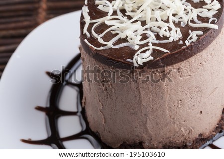 Brown Chocolate mousse cake with white chocolate on top and heart chocolate shape on suggar powder.