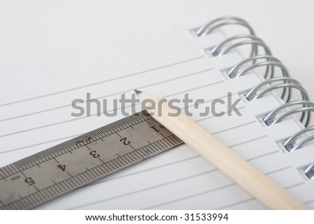 spiral note pad with a pencil and a ruler
