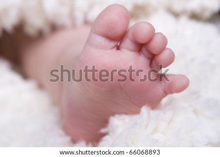 single small newborn baby foot on soft blanket