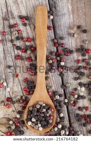 Various type of peppers on wood spoon and old wood table top view