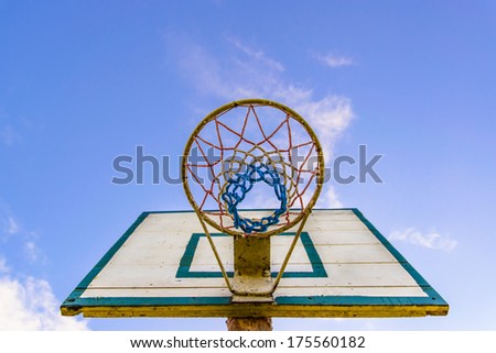Basketball basket visible from the bottom on the blue sky in background.