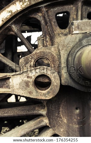 A fragment of an old damaged and rusty steam engine, old style type locomotive, vertical frame.