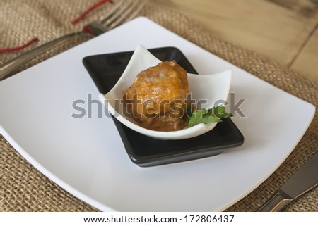 Meatball of minced meat with parsley on small plates in black and white
