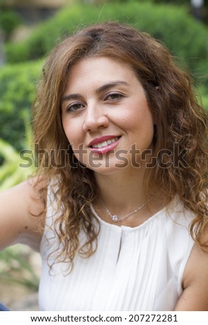 Portrait of smiling woman with green nature background