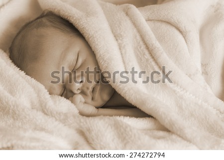 Newborn baby sleeping very quiet on a white blanket.