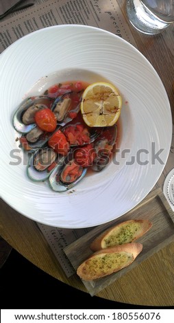Greenshell mussels with lemon on a plate with bread