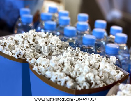 A row of popcorn buckets and water bottles in a cinema