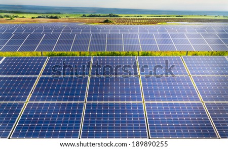 Solar power plant on the background of green fields and hills