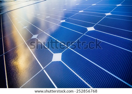 Photovoltaic cells and reflection of sunset light and clouds