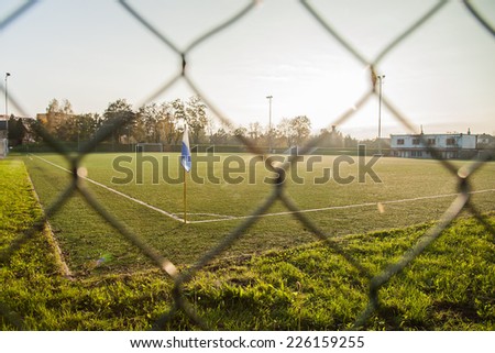 Empty football ground corner with flag and sunset