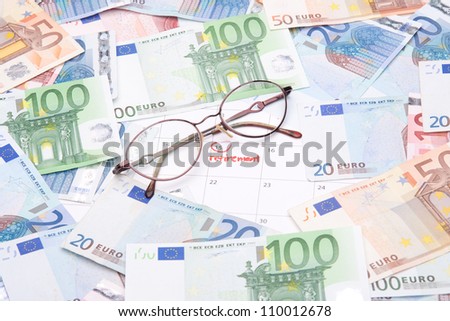 Look forward retirement payday - retirement written in calendar, money and glasses.