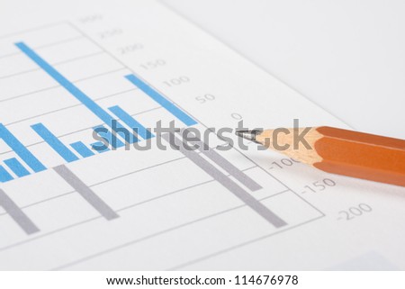 Business report, pencil and graph. Selective focus on pencil lead.