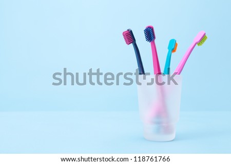Four toothbrushes - dental hygiene. Selective focused on front toothbrush, blue background.