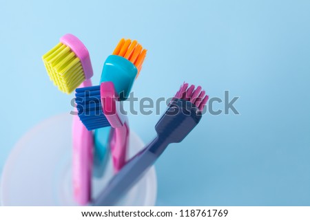 Four toothbrushes - dental hygiene. Top view, selective focused on top of right toothbrush, blue background.