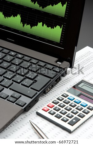 Modern business and stock market analyze with laptop, calculator, pen and printed data sheet