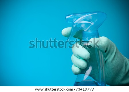 Sanitation worker hand with cleaning agent on blue background