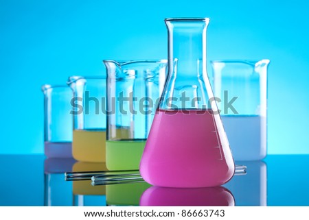 Laboratory Glassware - chemical flasks with colored solution. Focused on front flask with purple solution.