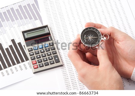 Navigate to success in business and compare right direction in business concept. Man with compass directed to success word. Calculator, sheet and graph represent business.