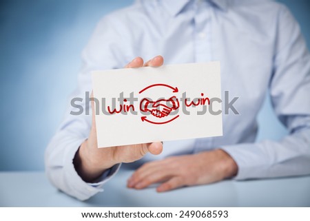 Win-win partnership strategy concept. Businessman with drawn win-win scheme on card and handshake partnership agreement.