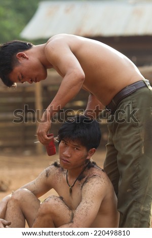 XEKONG, LAOS, APRIL 13 : An unidentified man haircut with clipper at ground in the village of Xekong, Laos, on April 13, 2014