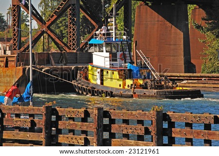Tugboat pushing barge through the locks