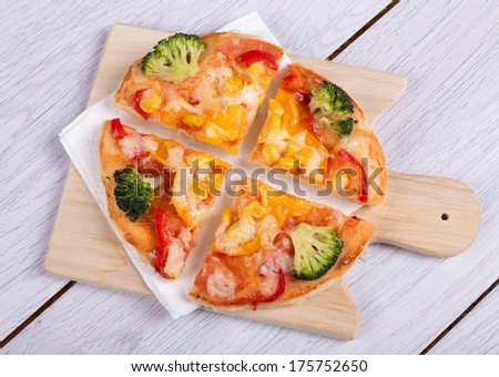 small vegetable pizza on wooden board