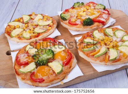 small vegetable pizza on wooden board