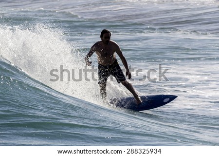 Ocean view and people surfing in Tavira Island coast beach, Algarve, Portugal.