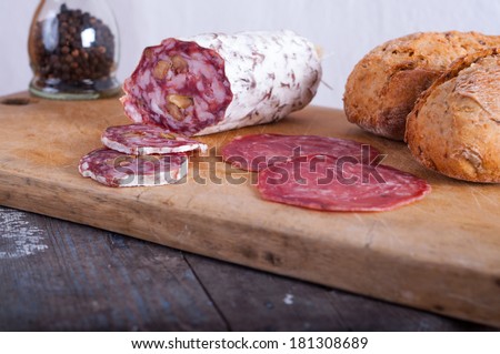 Cut sausage laying on board. This is kind of italian, half raw sausage.
