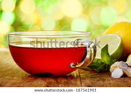 A cup of hot tea on wooden table against spring blurred background. Tea time concept. Healthy lemon tea