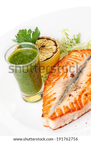 Grilled salmon steak with vegetable garnish. Healthy seafood dinner.