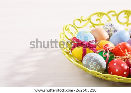 Colorful painted easter eggs on a elegant openwork dish