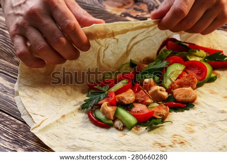 Wrapping traditional shawarma wrap with chicken and vegetables