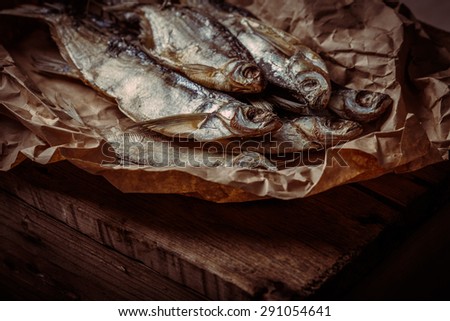 Dried fish on wooden table. Selective focus, narrow depth of field. Instagram filter styled