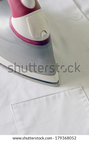 Detail of an steam iron ironing a white dress