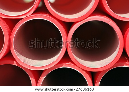 Red plastic pipes stacked. Industrial concept