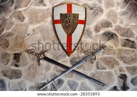 Middle age metallic shield and two swords on a wall