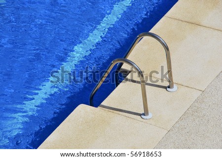 Steps on the swimming pool. Metallic ladder on the pool