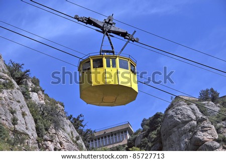 Yellow cable car suspended on the wires. Aerial transport