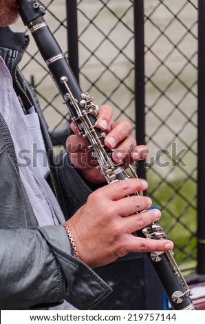A man plays a clarinet in the stree