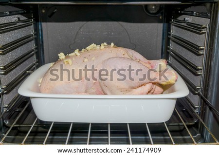 Chicken in a tray ready to be roasted in the oven with garlic, oil, honey and lemon