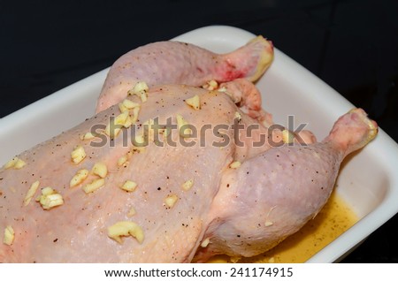 Chicken on a tray ready to be roasted with garlic, oil, honey and lemon