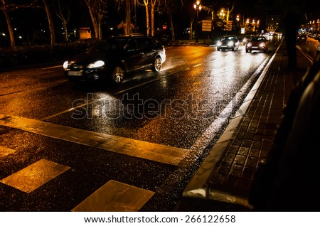 Vehicles in motion at night after rain. Night city lights