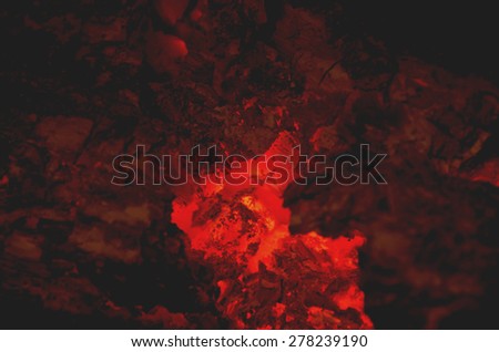 Embers are burning in a fireplace. Infernal background